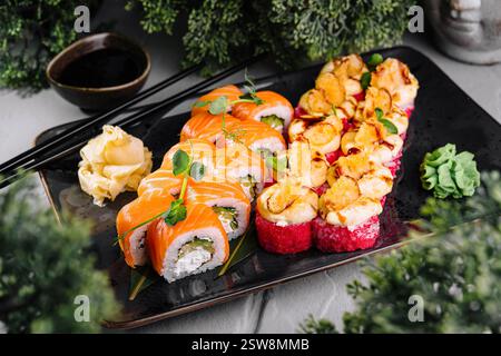 Köstliche Sushi-Brötchen werden auf Teller mit Sojasauce und Wasabi serviert Stockfoto