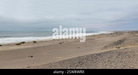 Landschaft mit Wellen an der Küste der Wüste, aufgenommen im hellen, bewölkten Licht des späten Frühlings in der Nähe von South West Seal Schiffswrack, Skeleton Coast, Namibia Stockfoto