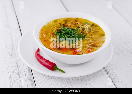 Dampfende heiße Schüssel mit Hühnernudelsuppe mit Kräutern und Gewürzen Stockfoto