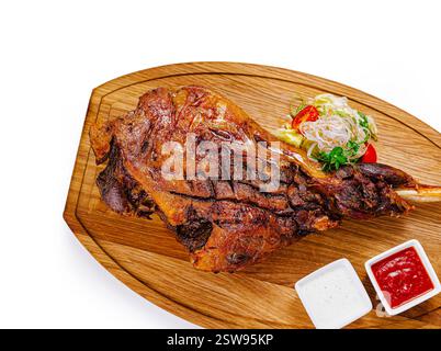 Gebratene Lammkeule mit Gemüse auf Holzschneidebrett Stockfoto