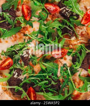 Köstliche heiße Pizza mit Pilzen und Rucola aus nächster Nähe Stockfoto