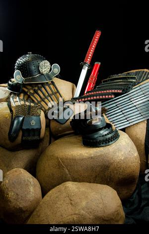 Die Rüstung und das Schwert der Samurai-Krieger sind auf einem Steinhaufen ausgestellt. Der Begriff von Stärke und Macht sowie die historische Bedeutung des Samur Stockfoto