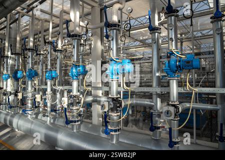 Heizungs- und Wasserversorgungssystem für Gewächshäuser. Rohre mit Manometer zur Regelung von Temperatur und Druck Stockfoto