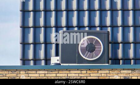 Luftquellenwärmepumpeneinheit, die im Freien in einem modernen Haus mit Solarpaneelen in den Niederlanden installiert wird Stockfoto