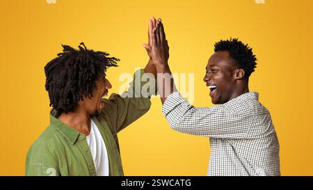Zwei Fröhliche Schwarze Jungs, Die Sich Gegenseitig High Five Gaben Und Lachten Stockfoto