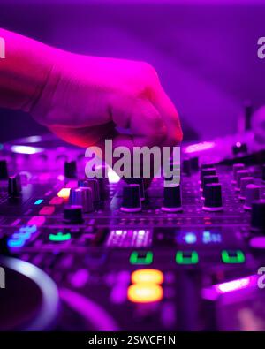 Ein DJ, der sich auf einem Brett in einer Clubumgebung mischt Stockfoto