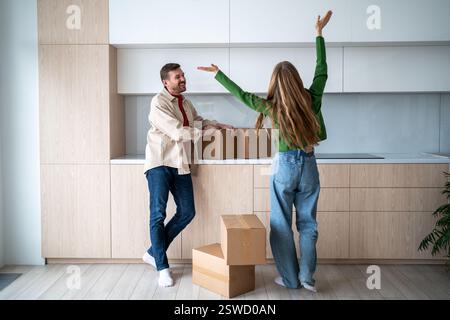 Eine überglückte Frau und eine glückliche Umsiedlung des Mannes. Lange erwartete Wohnung mit genehmigter Hypothek. Stockfoto