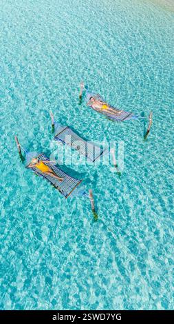 Entspannende Hängematten schweben sanft im kristallklaren Wasser von Koh Kood, Thailand an einem sonnigen Tag Stockfoto