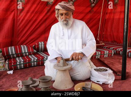 Dibba Al Baya. Februar 2025. Ein omanischer Mann in traditioneller Kleidung demonstriert die handwerkliche Keramik auf einem Kulturfestival in Dibba Al-Baya, Musandam Governorate, Oman, am 20. Februar 2025. Quelle: Yang Yiran/Xinhua/Alamy Live News Stockfoto