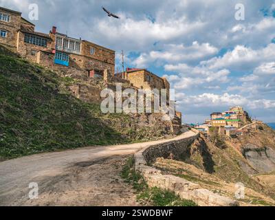 Sandige, gewundene Straße zum Bergdorf. Sonniger Blick auf den Schurken auf dem Felsen. Authentisches dagestanisches Bergdorf Choh. Rus Stockfoto