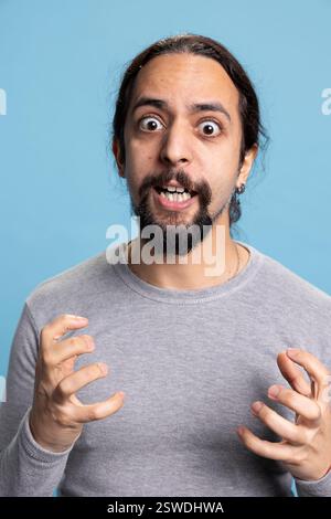 Frustrierte wütende Person, die ihre intensiven Emotionen und Ängste vor der Kamera zum Ausdruck bringt und Probleme des Wutmanagements und Wut zeigt. Junger Erwachsener, der wütend und irritiert über etwas im Studio ist. Stockfoto