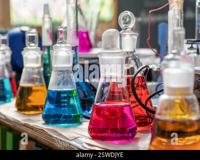 Kolben mit farbigen Reagenzien auf dem Tisch. Stockfoto
