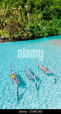 Entspannen Sie auf Hängematten über kristallklarem Wasser in Koh Kood Thailand Stockfoto