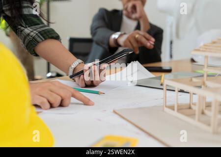 Selbstbewusste Geschäftsfrau mit Architekturmodell im Büro. Daten funktionieren und Tablet-Notebook. Architekt erklärt den Projektplan den Kunden. Konz. Suchen Stockfoto