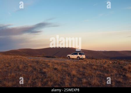 White Car suv parkte in der Nähe der malerischen Route Straße in der herbstlichen Kaukasuslandschaft. Naturkaukasus Wahrzeichen und beliebte Reiseziele. Lu Stockfoto