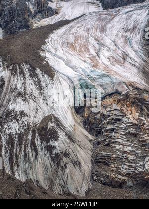 Naturhintergrund dunkler Gletscheroberfläche mit Rissen und Kratzern. Minimaler natürlicher Hintergrund aus eisiger Wand und Eisblöcken Stockfoto