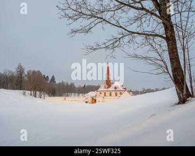 Wintermorgen frostiger Sonnenaufgang. Weiße schneebedeckte minimalistische Landschaft mit altem maltesischen Palast in wunderschöner natürlicher Landschaft. Gatchina. R Stockfoto