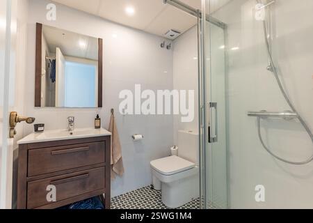 Ein Bild eines einfachen Badezimmers mit Dusche und Holzschrank in der Ferienwohnung Stockfoto
