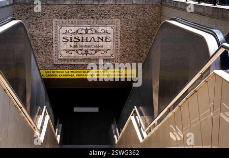 Blick auf den Eingang der U-Bahn-Station Şişhane in Istanbul mit Rolltreppen, die nach unten führen. Das Bahnhofsschild ist gut sichtbar und mit einem Dekor versehen Stockfoto