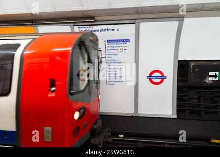 Tottenham Court Road U-Bahn-Station, London, Großbritannien, mit einem fahrenden U-Bahn-Zug, der in den Bahnsteig fährt. Logo und Routenkarte. Nördliche Linie nach Morden Stockfoto