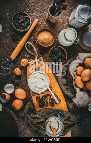 Verschiedene Backzutaten auf Vintage-Holztisch, braune Farben. Vorbereitung für das Backen zu Hause. Stockfoto
