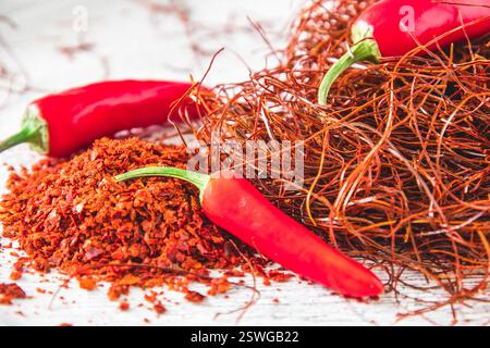 Chilischoten, Flocken und Fäden auf weißem Hintergrund, Nahaufnahme Stockfoto