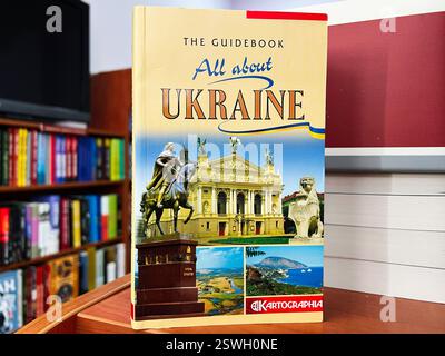 Lemberg, Ukraine - 20. Februar 2025: Ein Reiseführer über die Ukraine wird auf einem Bücherregal mit farbenfrohen Hintergründen ausgestellt Stockfoto