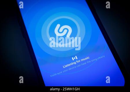 Ein iphone-Smartphone-Bildschirm, der die Shazam App-Oberfläche anzeigt und die Funktion zum Musikhören in einer dunklen Umgebung anzeigt, Apple iphone 14 Pro Stockfoto