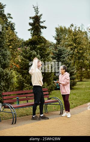Ein liebevolles Paar teilt ein freudiges Gespräch in einem wunderschönen Park, umgeben von Bäumen. Stockfoto