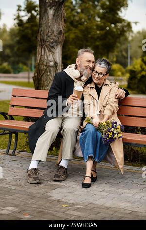 Ein liebevolles Paar lacht auf einer Bank, die von üppigem Grün umgeben ist und Wärme und Freude annimmt. Stockfoto