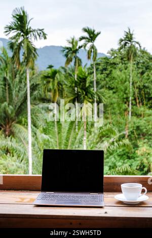 Arbeiten Sie fernab im tropischen Paradies mit Kaffee auf Bali und üppigem Grün in der Umgebung Stockfoto