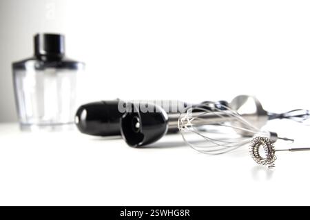 Modernes Set für Eintauchmixer mit Schneebesen, Milchaufschäumer und Schüssel auf weißem Hintergrund. Moderne Haushaltsgeräte. Stockfoto