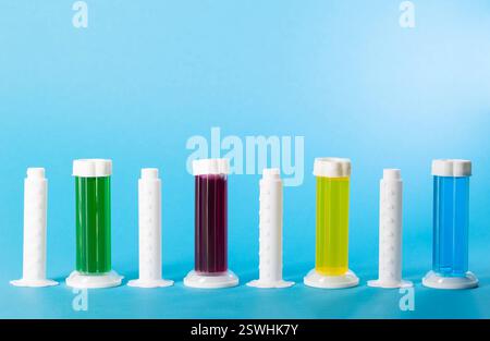 Set aus mehrfarbigen Gelspritzen mit Desinfektionsmittel und Toilettenreiniger auf blauem Hintergrund. Kopierbereich für Text Stockfoto
