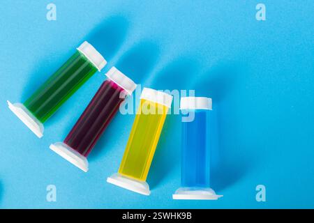 Set aus mehrfarbigen Gelspritzen mit Desinfektionsmittel und Toilettenreiniger auf blauem Hintergrund. Kopierbereich für Text Stockfoto