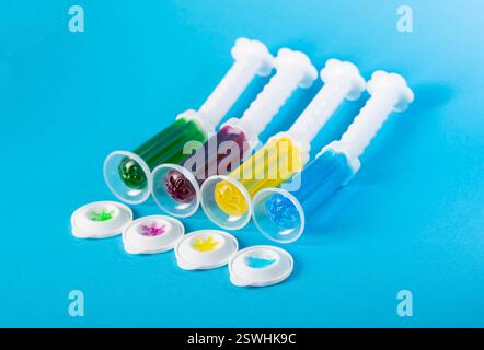 Set aus mehrfarbigen Gelspritzen mit Desinfektionsmittel und Reiniger zur Reinigung der Toilettenschüssel auf blauem Hintergrund, Hygiene. Stockfoto