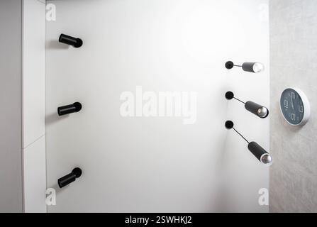 Moderne abgehängte Decke mit verschiedenen schwarzen LED-Lampen an einer weißen Decke in der Küche. Kopierbereich für Text Stockfoto