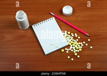 Schreibblock und die Pillen auf dem Holztisch Nahaufnahme Stockfoto