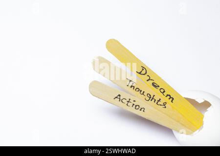 Nahaufnahme einer handgeschriebenen Nachricht auf einem Eisstock mit der Aufschrift Traum, Gedanken, Aktion Stockfoto