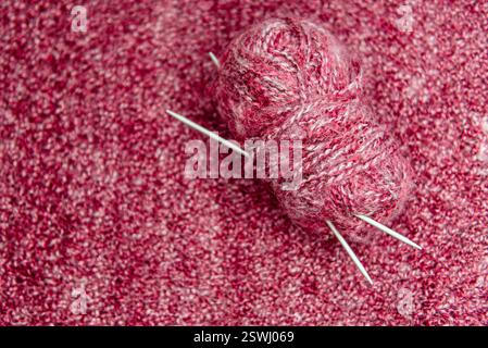 Strukturierter Hintergrund Nahaufnahme aus rosafarbenem, selbstgemachtem Strickstoff mit großen Nähten. Stockfoto