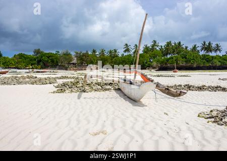 Rostiges Holzboot Banka am Strand vor Anker. Tropische Ebbe Landschaft mit Segelbooten. Nautisches Schiff in der Nähe der Palmenküste, Afrika, Sansibar. Stockfoto