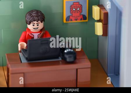 Tambow, Russische Föderation – 12. Februar 2025 Lego Peter Parker Minifigur arbeitet hinter einem Laptop an seinem Arbeitsplatz im Büro Stockfoto