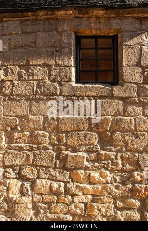 Kleines Fenster in Steinmauer Stockfoto
