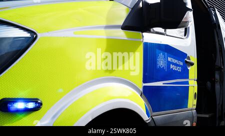 Metropolitan Police Service Logo / Wappen auf der offenen Tür eines Polizeiwagens neben blinkendem Blaulicht - London, England Stockfoto