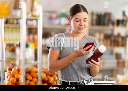 Frau, die ein Paket Ketchup scannt Stockfoto