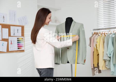 Modedesignerin bei der Messung von Jacke in der Werkstatt Stockfoto