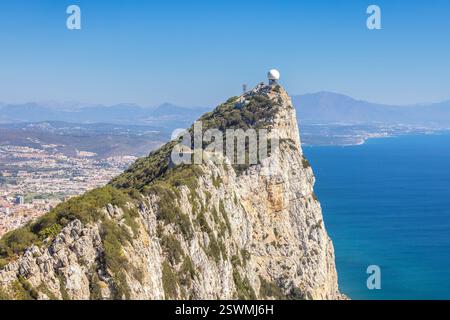 Ein atemberaubender blick auf die Küste mit einer zerklüfteten Klippe, geschmückt mit üppiger Vegetation und gekrönt von einer Radaranlage. Die Szene bietet atemberaubend Stockfoto