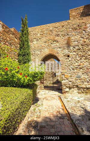 Alcazaba, Palast und Festung in Malaga Stadt in Andalusien, Spanien, Europa. Uralter Steinbogen mit eisernem Tor, der durch eine Weggrenze führt Stockfoto