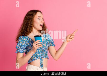 Aufgeregte junge Frau, die eine Kaffeetasse hält Stockfoto