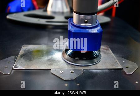 Schleifen Sie das Polierwerkzeug der bearbeiteten Oberfläche eines runden Metallteils. Stockfoto