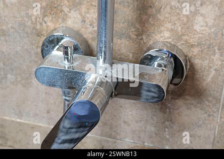 Dreckiger Wasserhahn mit Salzablagerungen aus dem Wasser im Bad auf modernen, dunklen Marmorfliesen. Sauberkeit und Reinigung. Sorge um Haus und Ordnung. Lifestyle. Stockfoto